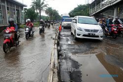 FOTO BANJIR JAKARTA : Melintasi Jalan Berlubang 