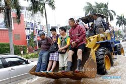 FOTO BANJIR JAKARTA : Menumpang Alat Berat Terjang Banjir