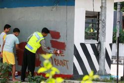 FOTO VANDALISME JOGJA : Remaja Hapus Grafitti di Pos Polisi