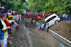 FOTO MOBIL NYEMPLUN SELOKAN : Warga Angkat Mobil Nyemplung ke Selokan