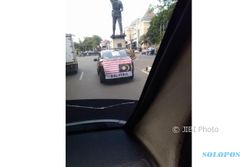 Mobil Berspanduk Bendera Malaysia Terbalik Lewat Jl Slamet Riyadi Solo
